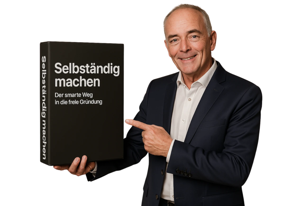 Torsten Schrimper hält eine schwarze Box mit der Aufschrift ‚Selbständig machen – Der smarte Weg in die freie Gründung‘ und zeigt mit einem Lächeln darauf